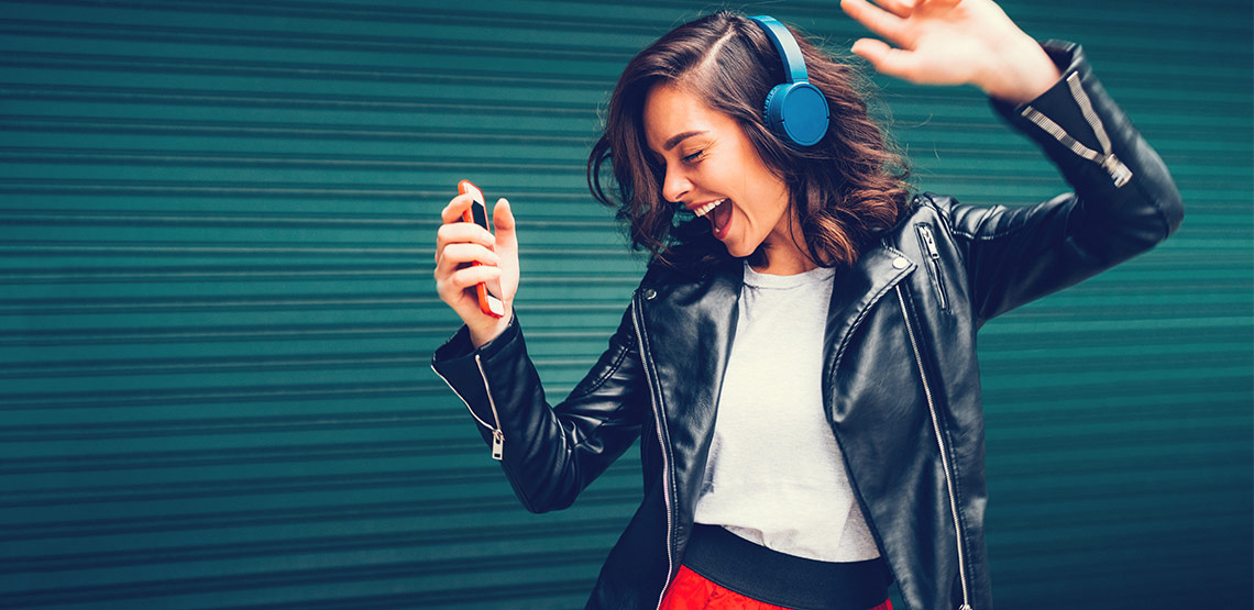 Woman wearing headphones and dancing