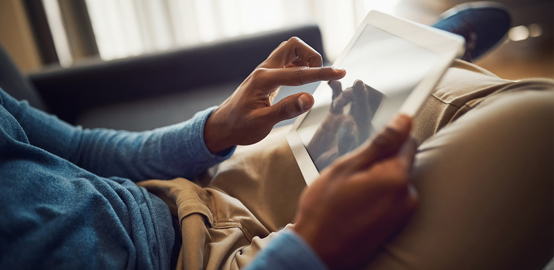 Man sitting on couch using a tablet