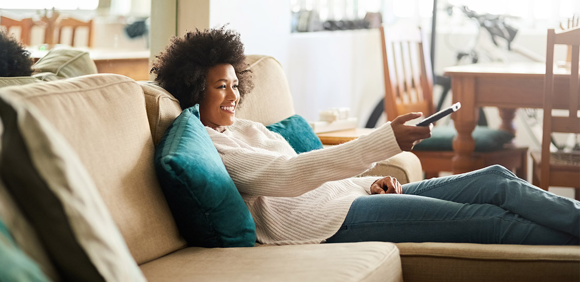 Woman pointing remote at TV