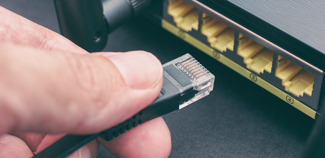 Someone plugging in cord to router