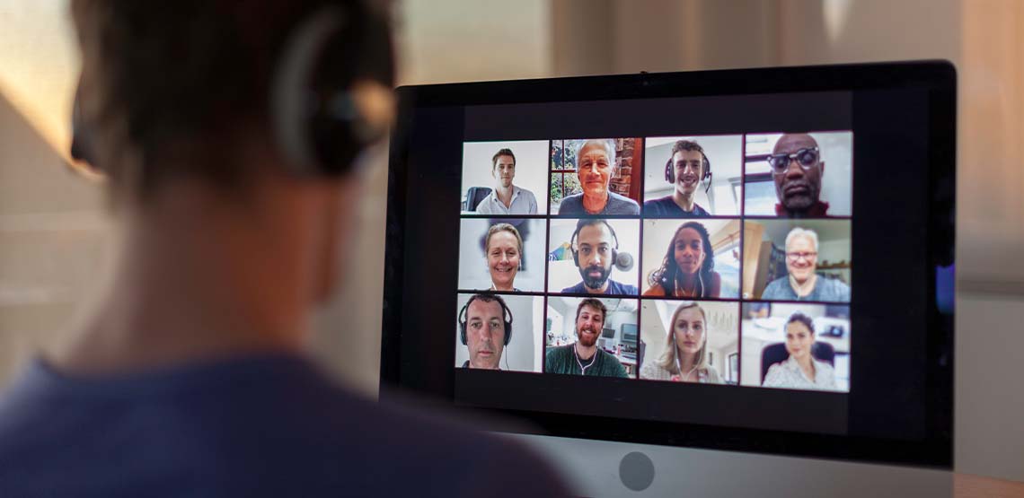 Someone sitting in front of a monitor on a video conference call.