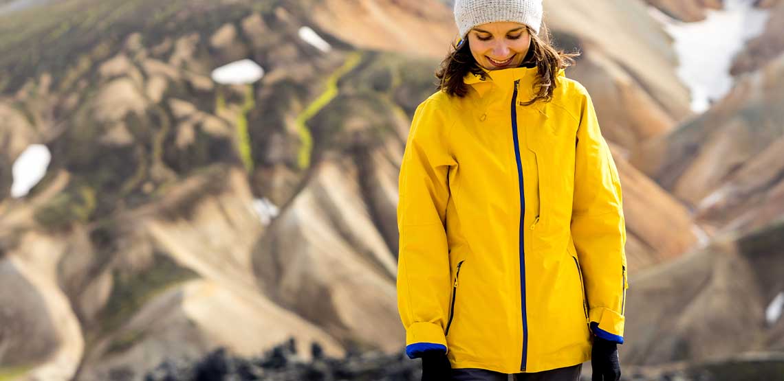 A person wearing a yellow heated coat outside.