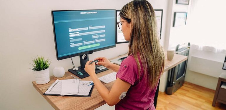 A medical professional using medical billing software on a computer.